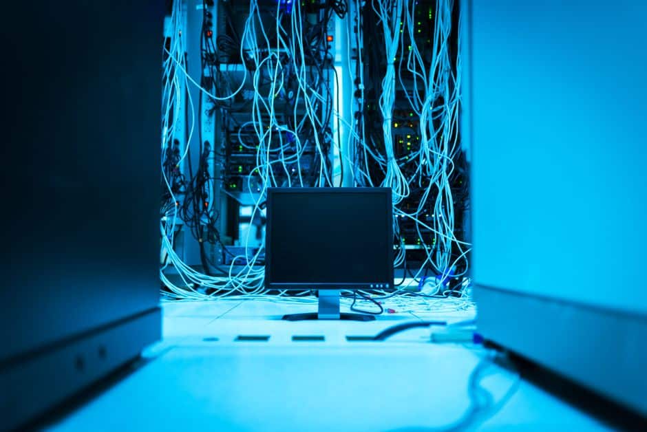 A small home server device with connected cables on a shelf