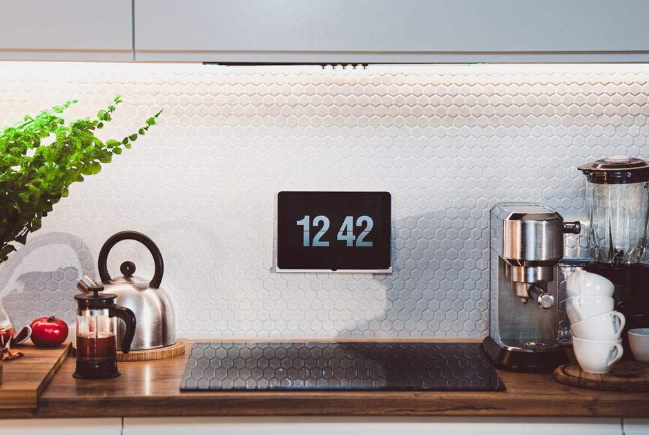 A tablet showing a home automation dashboard interface on a kitchen counter